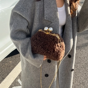 Detailed view of brown plush teddy crossbody bag with pearl clasp and gold chain strap