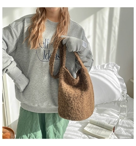 Brown bouclé plush bucket bag showing soft texture and spacious capacity in bedroom setting