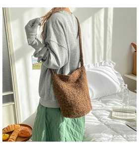 Detailed close-up of brown plush bucket bag with fuzzy texture and matching strap