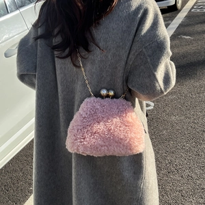 Detailed texture of pink faux fur crossbody bag with golden chain and silver ball clasp