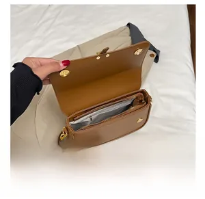 Internal view of brown PU leather handbag showing zippered pockets and gold hardware