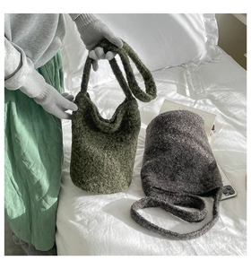 Detail of plush knitted bucket bag texture in olive green and dark grey colors
