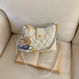 Chic beige quilted hobo bag with gold hardware and adorable puppy plush charm