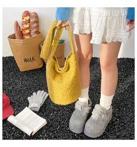 Detail of plush yellow bucket bag paired with wool mules and warm autumn outfit