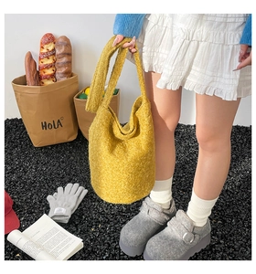 Detailed texture of yellow plush bucket bag with shoulder strap for autumn casual style