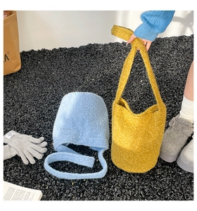 Detail of plush bucket bags in light blue and yellow colors with soft lamb wool texture