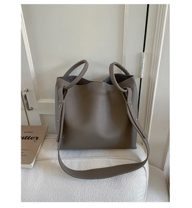 Detail view of large lychee texture tote bag with round handles and metal rivet reinforcement