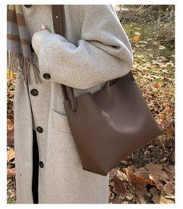 Close-up of caramel brown lychee pattern leather bucket bag with adjustable strap detail