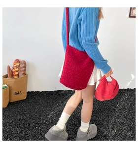 Winter casual red plush crossbody bucket bag styled with grey platform shoes and blue sweater