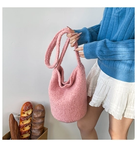 Detailed texture of pink plush lamb wool bucket bag with adjustable shoulder strap