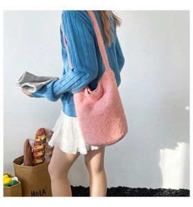 Detailed view of pink plush bucket bag with wide strap on model in Korean style