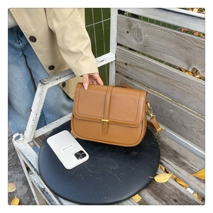 Detailed view of the brown leather crossbody bag with minimalist gold metal buckle