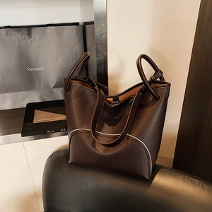 Dark brown pebble leather tote bag with unique curved front pocket and top handles