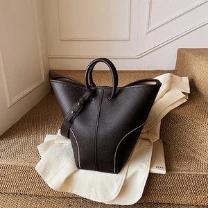 Dark brown pebble leather bucket tote bag with wide wings and adjustable shoulder strap