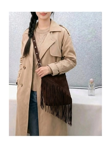 Close-up of bohemian brown suede tassel crossbody bag with vintage studded strap detail