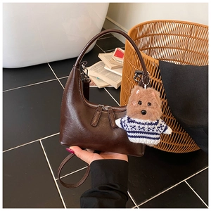 Detail of coffee crescent bag with zipper closure and brown puppy plush charm