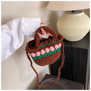 Detailed view of handmade crochet mini bag with pink tulip flowers and green leaves