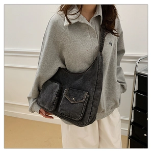 Detail of grey denim hobo bag featuring cargo pockets and vintage washed texture