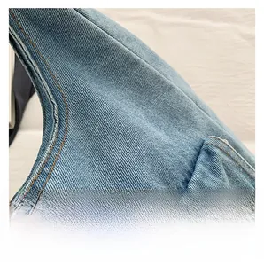 Macro detail of high-quality blue denim fabric with neat yellow contrast stitching