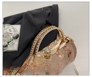 Detail of pink and brown sequin clutch featuring golden curved handles and diamond clasp