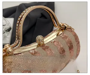Detail of elegant gold evening bag showing rhinestone-studded hardware and sequin texture