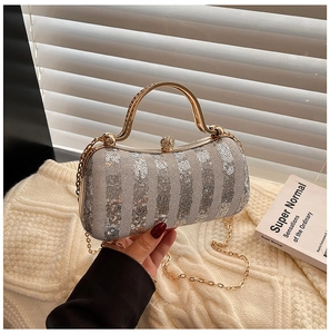 Close-up of silver sequin evening bag with metallic handle and elegant chain strap