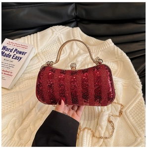 Detail of red sequined evening bag with golden metal handle and rhinestone ball clasp