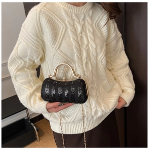 Detail of black sequined evening clutch with gold metal handle and chain strap for women