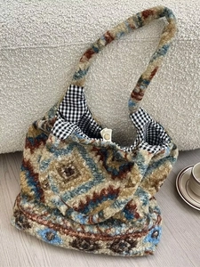 Détail du sac cabas en tricot avec motif géométrique bleu et doublure à carreaux