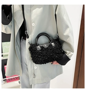 Detail of plush faux shearling crossbody bag featuring leather handles and metal buckle