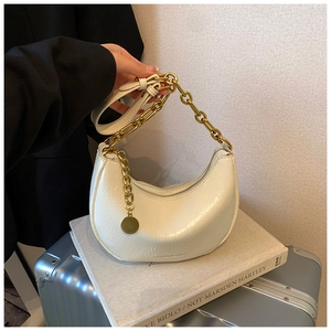 Detail of white glossy hobo bag with pleated texture and chunky gold metal chain strap