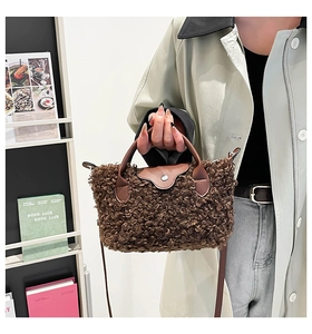 Detail of plush brown teddy bag with leather flap handle and adjustable shoulder strap