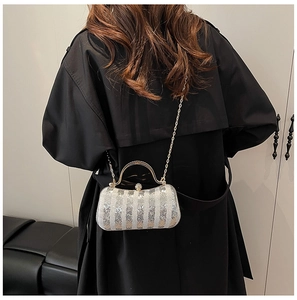 Detailed view of silver and gold sequin evening bag with elegant metal handle and chain