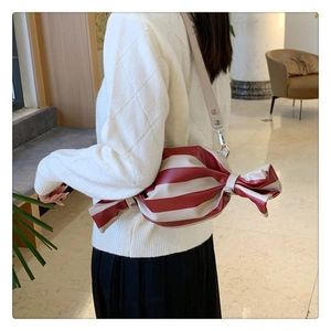 Détail du sac bandoulière en forme de bonbon avec rayures rouges et blanches et sangle