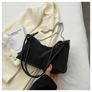 Detail of black rhinestone hobo bag with dual leather handles and silver chain strap
