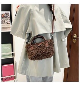 Brown teddy fleece mini bag worn with a light beige trench coat in a cozy room