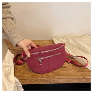 Detail of burgundy crescent waist bag with silver double zippers and wide strap