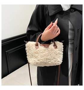 Detail of cream plush teddy fabric handbag with brown leather flap and metal button closure