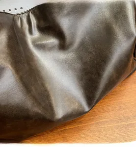 Macro shot of premium dark brown soft leather texture with natural grain on a tote bag
