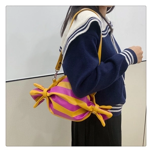 Détail du sac à bandoulière en forme de bonbon avec rayures jaunes et violettes stylées