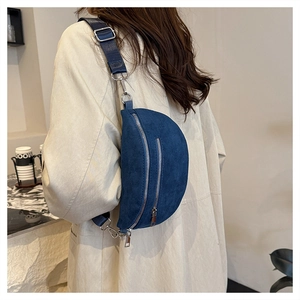 Blue suede half-moon crossbody bag with silver zippers and wide adjustable strap