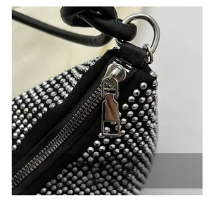 Detailed macro view of smooth silver zipper and silver studs on black leather bag