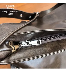 Detail of smooth silver metal zipper and striped lining on vintage brown leather tote bag