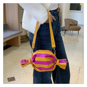 Détail du sac bandoulière en forme de bonbon avec rayures jaune et violet et lanière