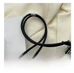 Detail showing crystal rhinestone surface with black leather strap and silver buckle