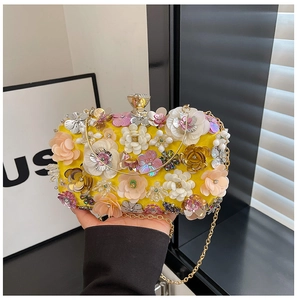 Detail of yellow evening bag with 3D floral embroidery, sequins and golden handle