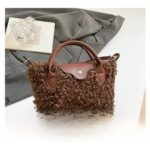 Top view of plush brown faux shearling handbag with leather flap and handle details