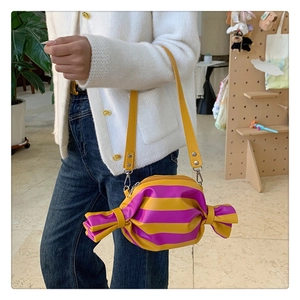 Détail du sac à bandoulière en forme de bonbon avec rayures jaunes et violettes en similicuir
