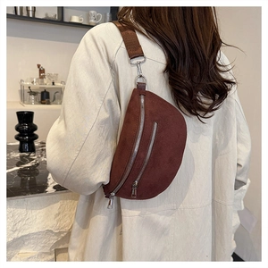 Detailed close-up of dark brown corduroy moon bag with wide strap and metal zippers