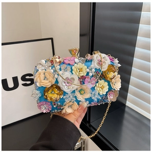 Detailed close-up of vibrant 3D sequin flower decorations on a luxury blue evening bag